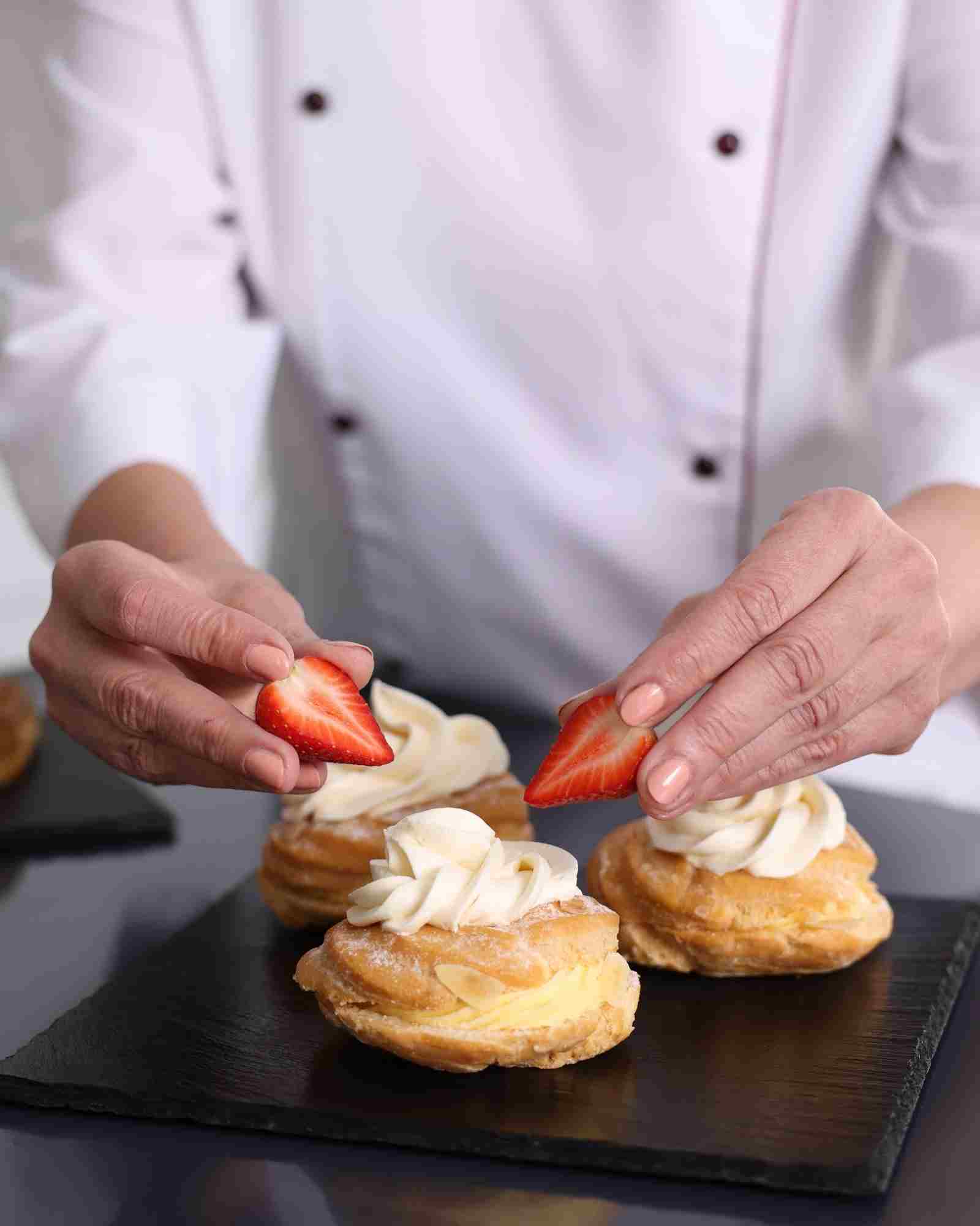 Pastry chef finishing a sweet creation in a workshop